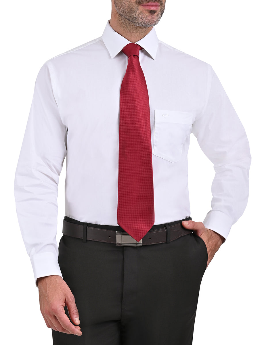 Un hombre con una camisa gris y pantalones rojos se para frente a